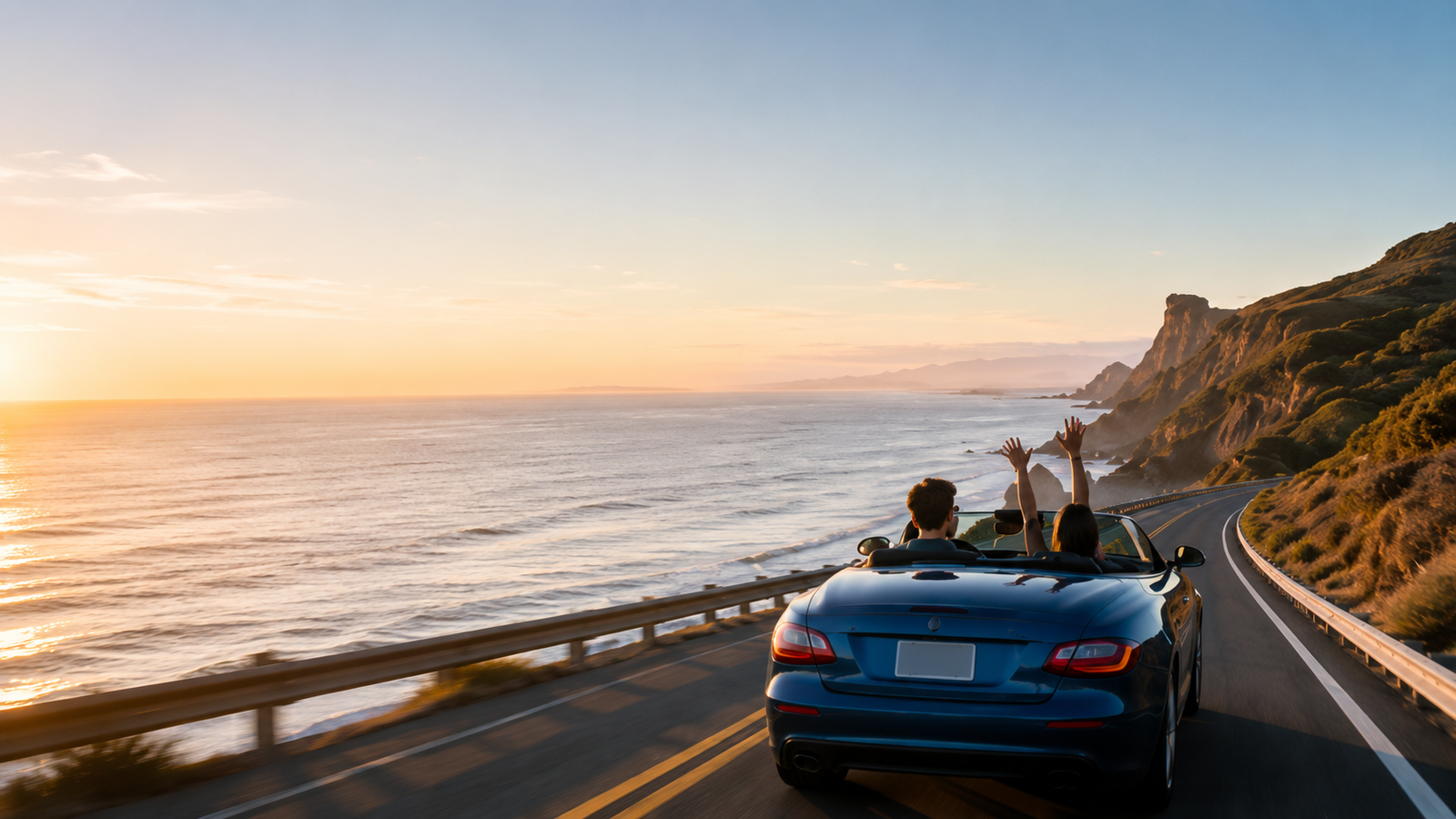 Couple driving a convertible on a coastal highway at sunset